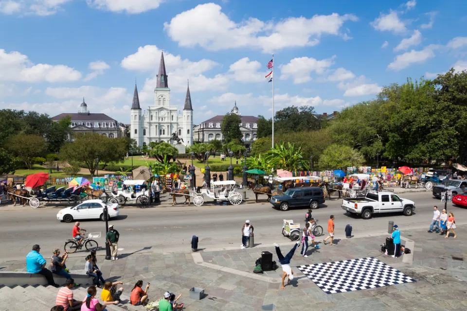 View of Jackson Square, New Orleans with cathedral and street dancers in foreground